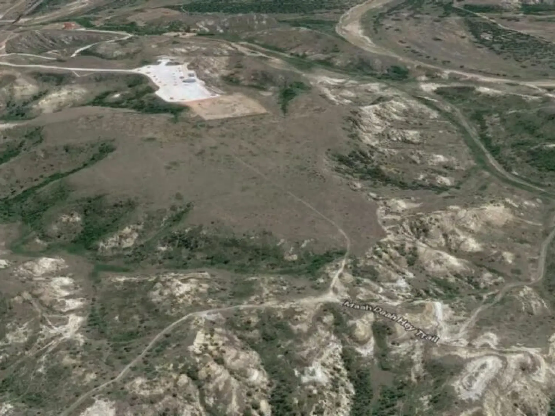 Aerial view of a rocky, barren landscape with winding roads.